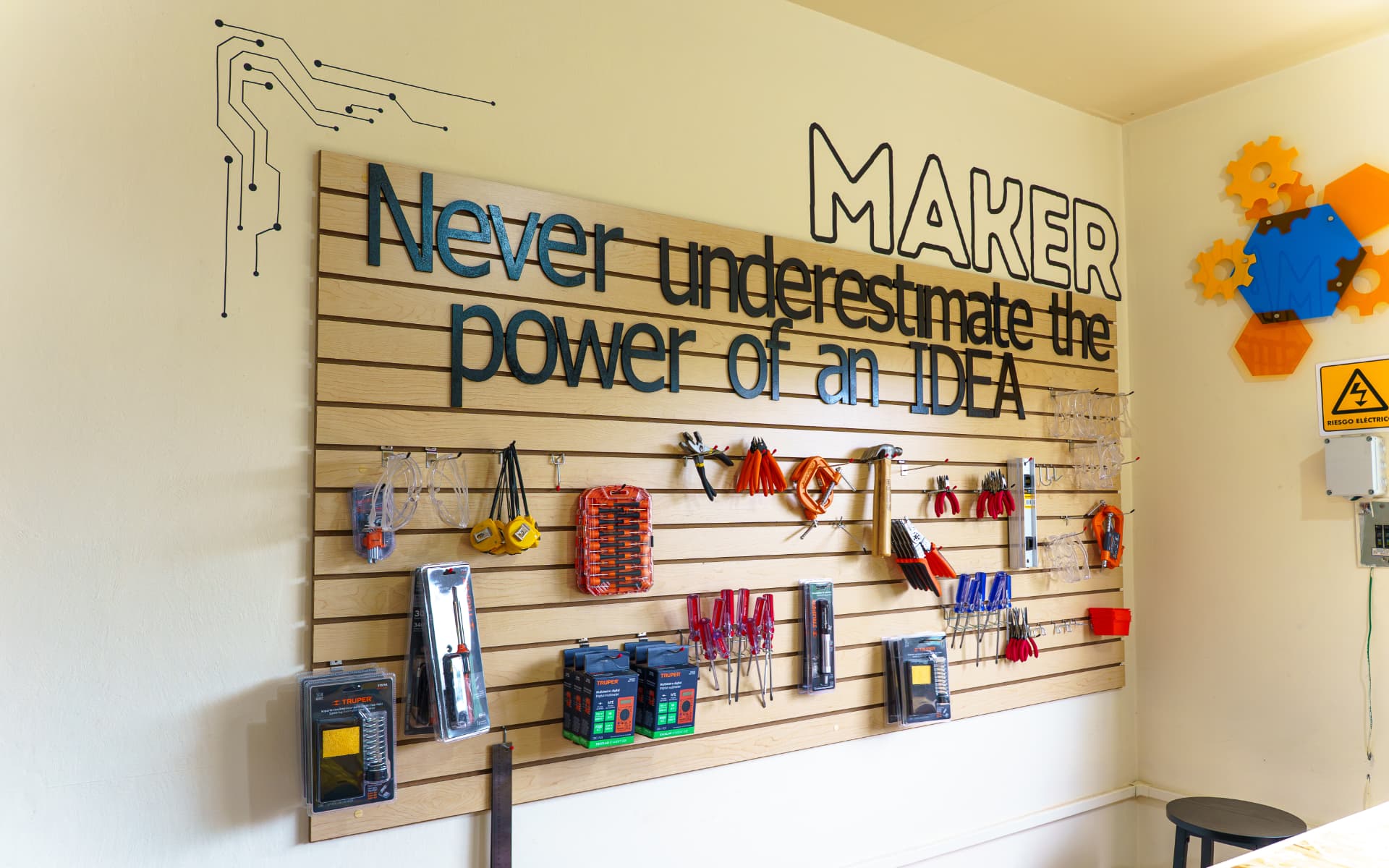Muro de herramientas de un espacio maker con frase inspiradora