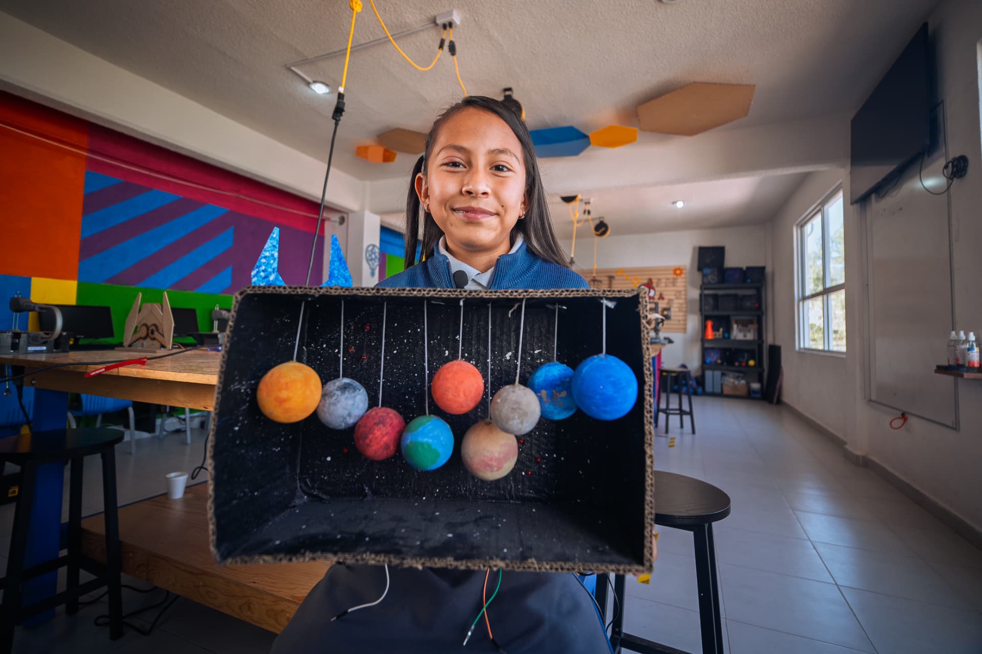 Alumna presentando su maqueta del sistema solar hecha a mano